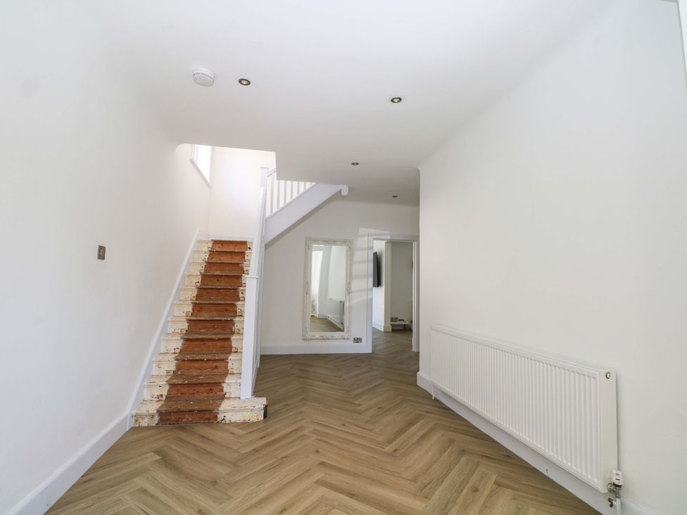 A hallway with a staircase and mirror at Shoreline Retreat in Bournemouth