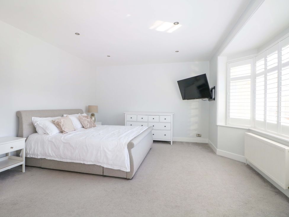 A bedroom with a bed and dresser at Shoreline Retreat in Bournemouth