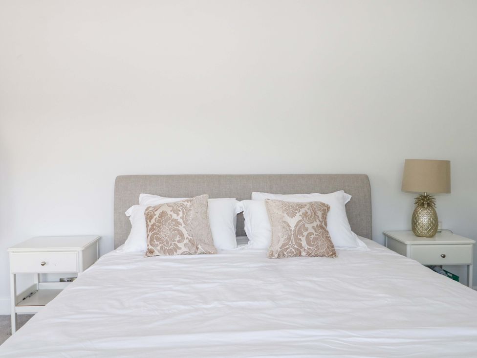 A bedroom with a bed and nightstands at Shoreline Retreat Bournemouth