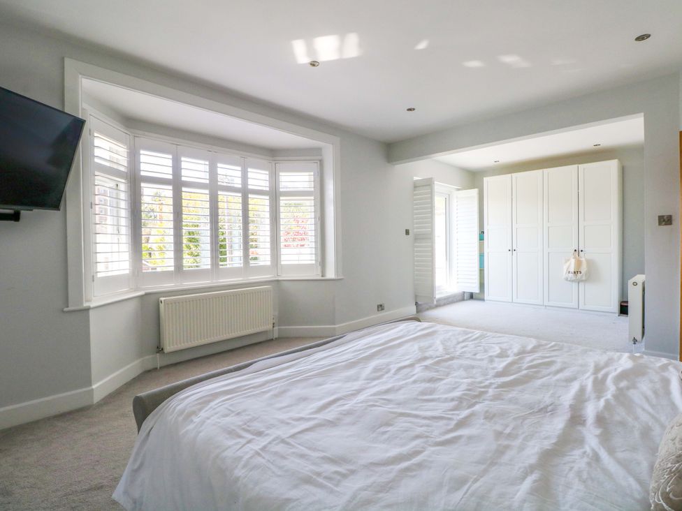 A bedroom with a bed and wardrobe at Shoreline Retreat in Bournemouth
