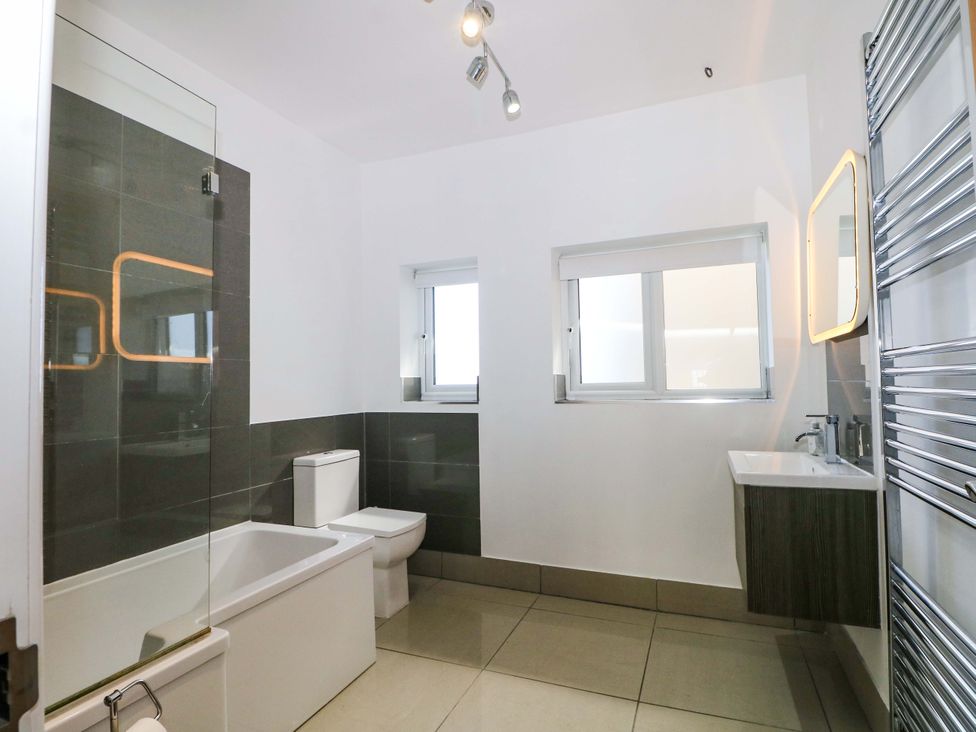 A bathroom with a bathtub, toilet, and sink at Shoreline Retreat in Bournemouth
