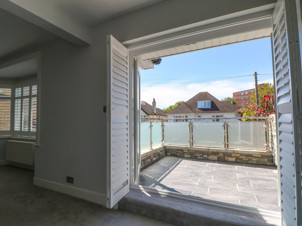 A view from a room to a veranda with glass railing at Shoreline Retreat in Bournemouth