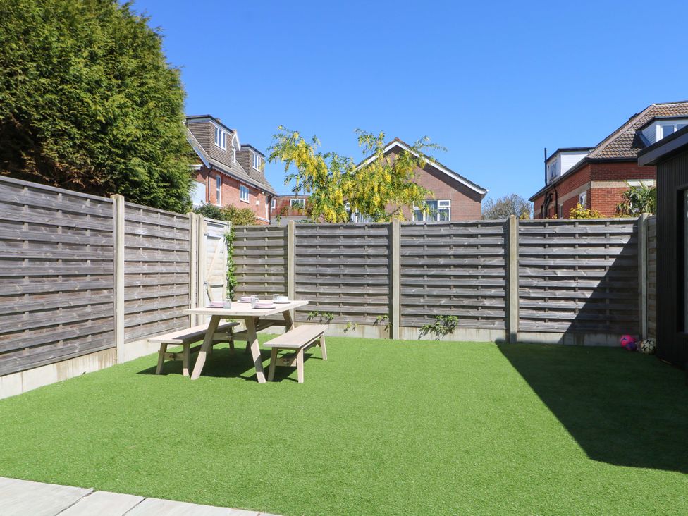 A garden with table and benches at Shoreline Retreat Bournemouth