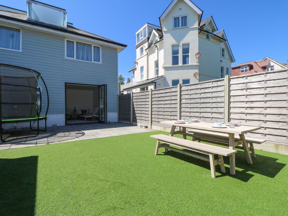 A garden with a table and benches at Shoreline Retreat in Bournemouth