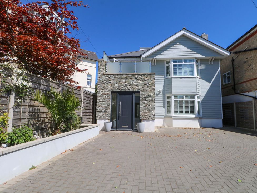 A house with a stone wall and driveway at Shoreline Retreat in Bournemouth