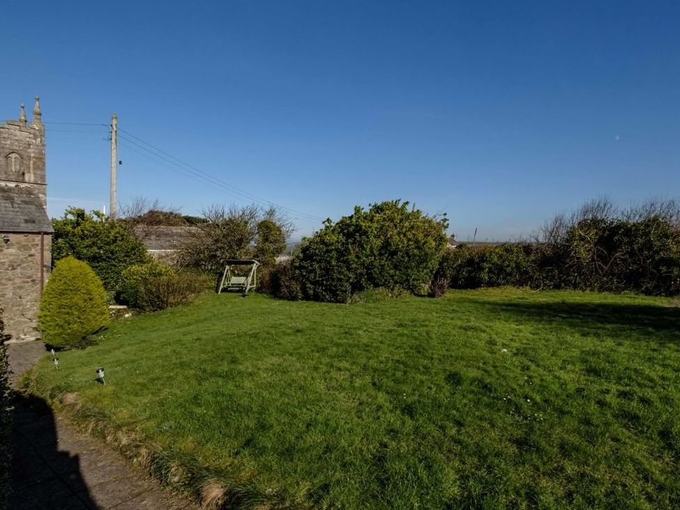 A garden with grass and bushes at Trehaverock Cottage in St. Endellion near Port Isaac
