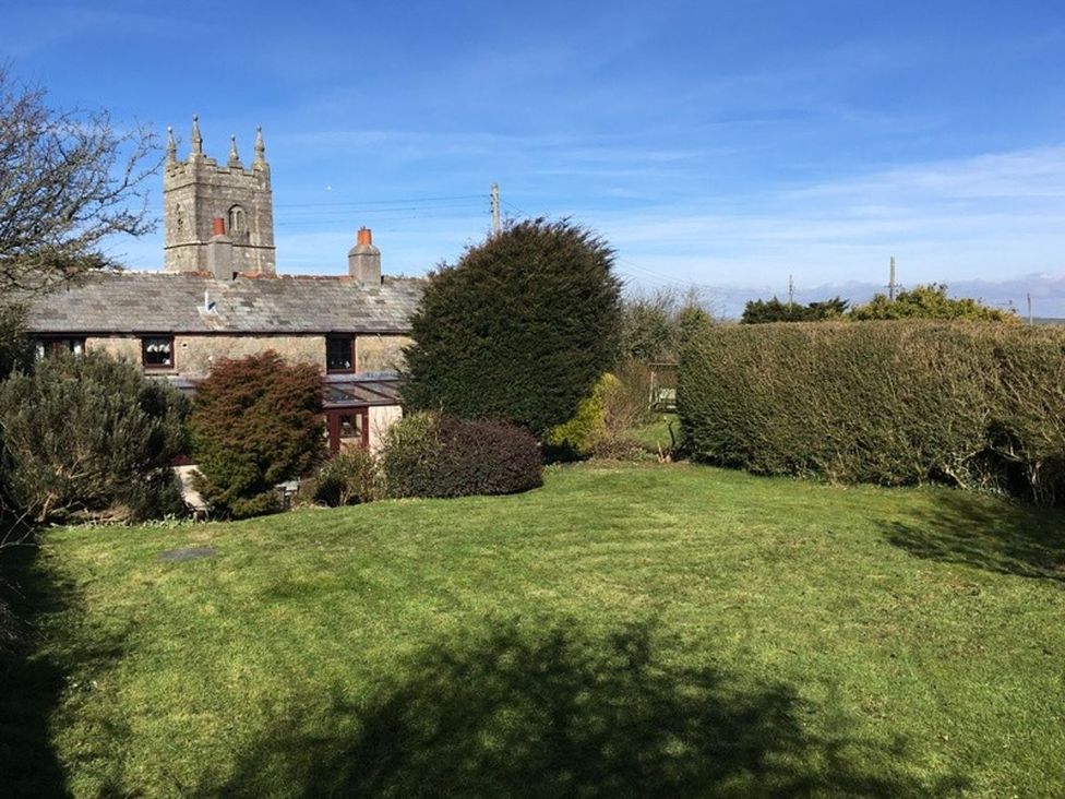 A garden with grass and trees at Trehaverock Cottage in St. Endellion near Port Isaac