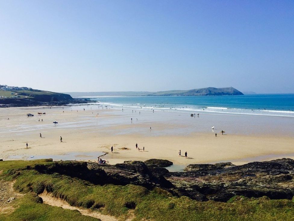 A beach view with people and ocean at Trehaverock Cottage in St. Endellion near Port Isaac
