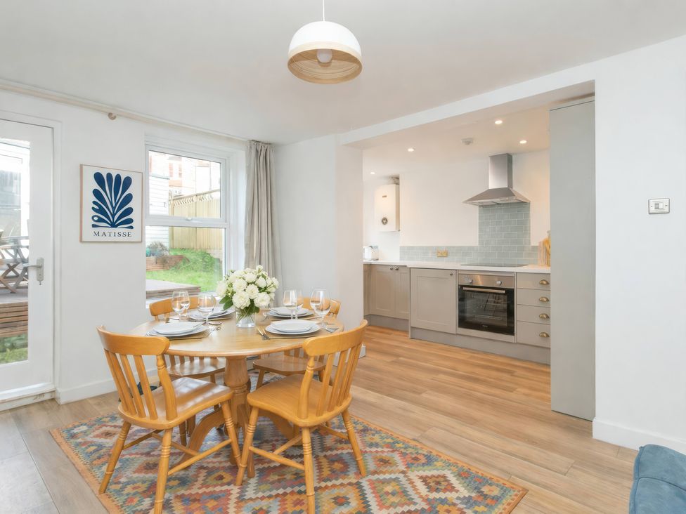 A dining room with a table and chairs at 19 East Cliff Gardens in Folkestone
