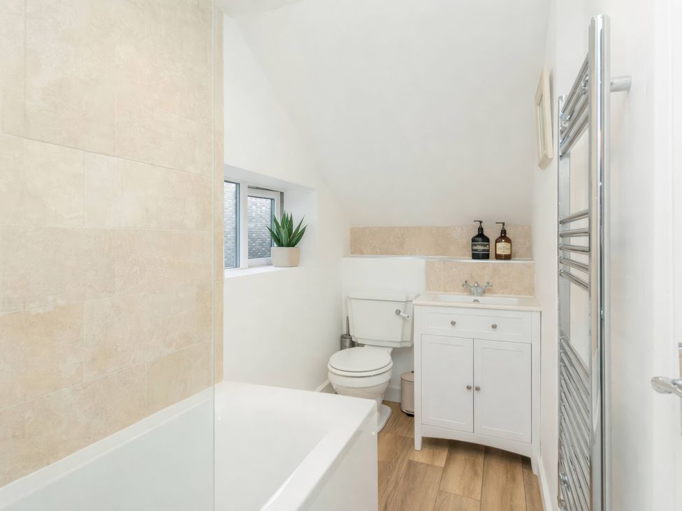 A bathroom with a bath tub and sink at 19 East Cliff Gardens in Folkestone