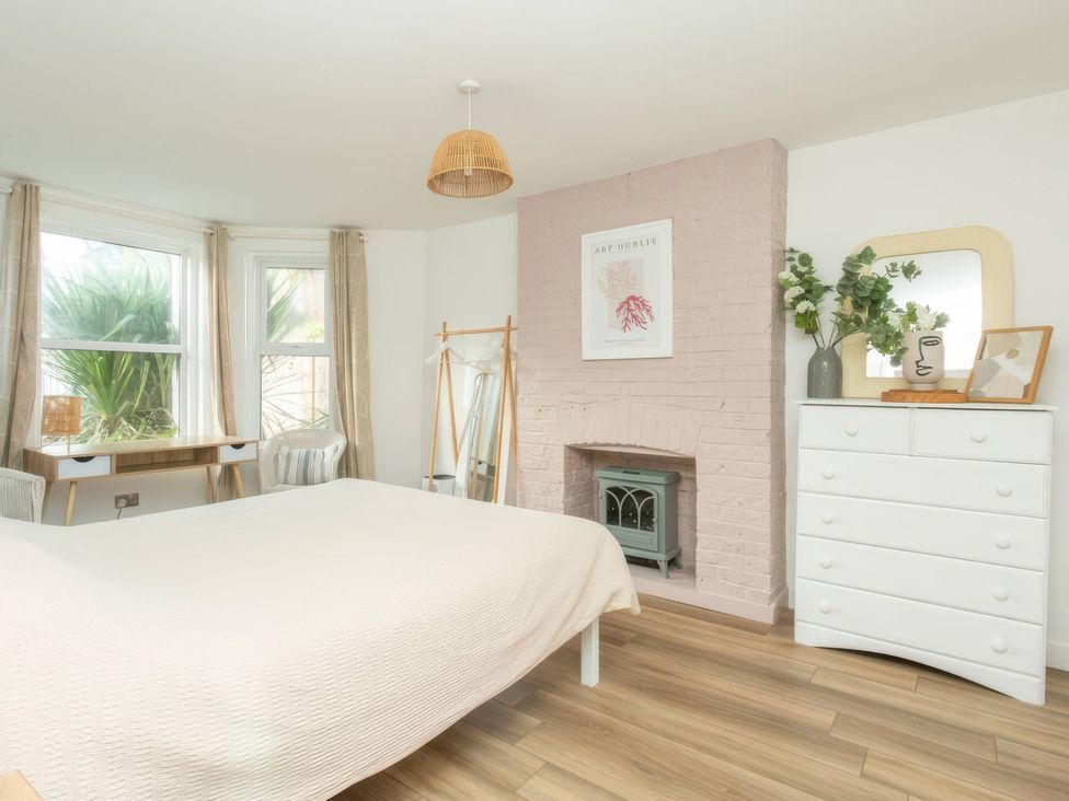 A bedroom with a bed and desk at 19 East Cliff Gardens, Folkestone