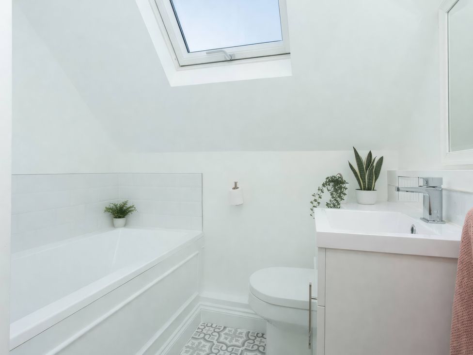 A bathroom with a bathtub, toilet, and sink at 19 East Cliff Gardens in Folkestone