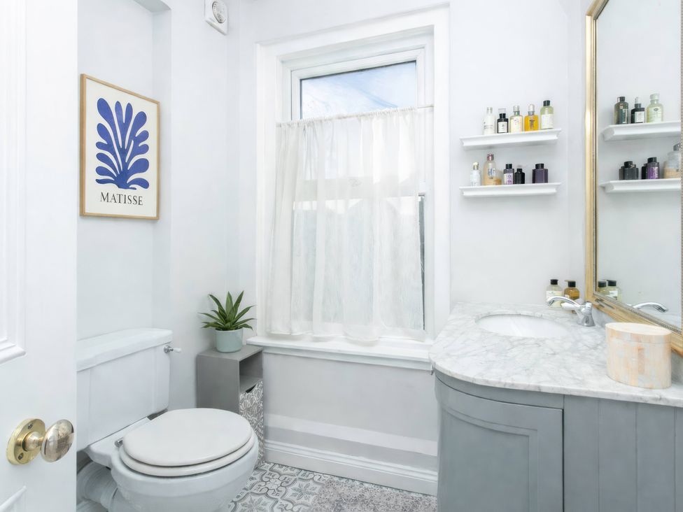 A bathroom with a toilet and sink at 19 East Cliff Gardens in Folkestone