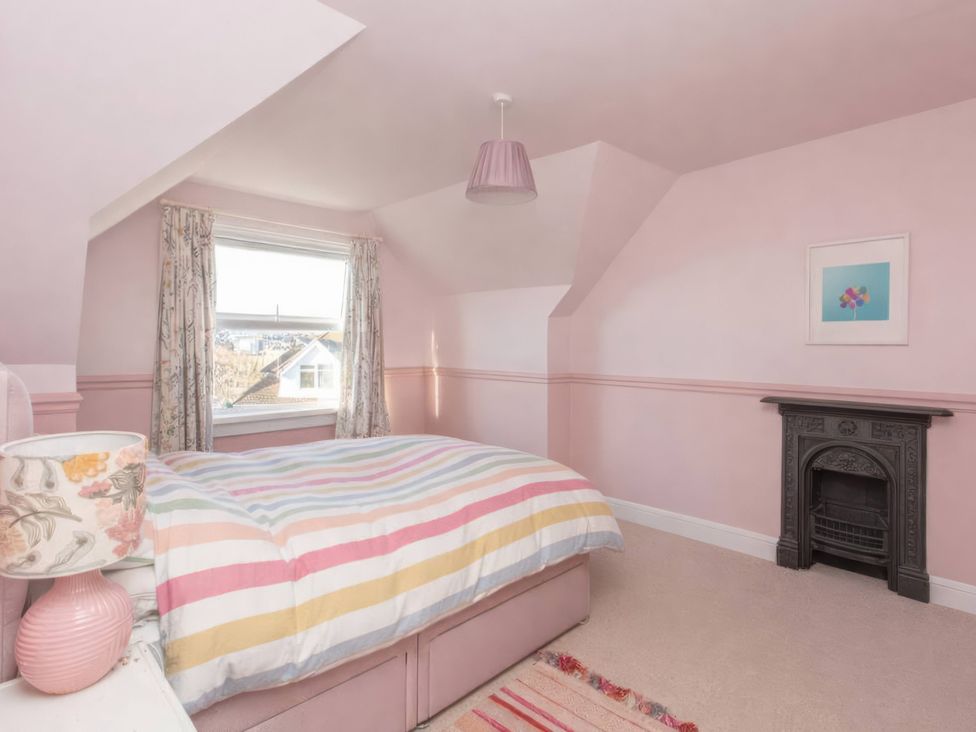 A bedroom with a bed and fireplace at 19 East Cliff Gardens in Folkestone
