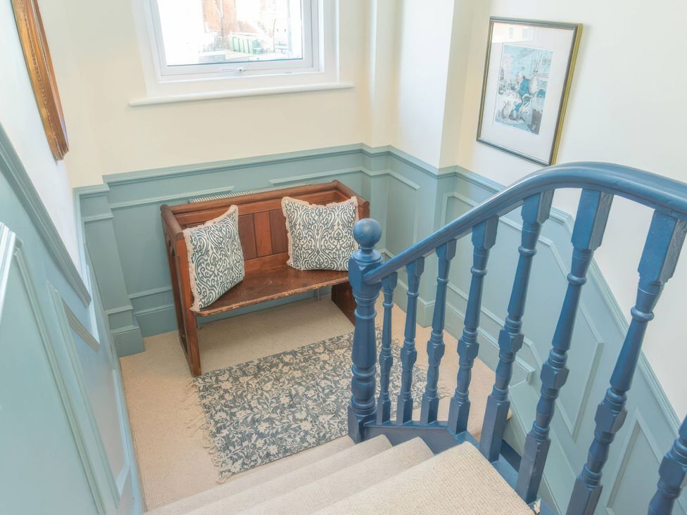 A staircase with a bench and cushions at 19 East Cliff Gardens Folkestone