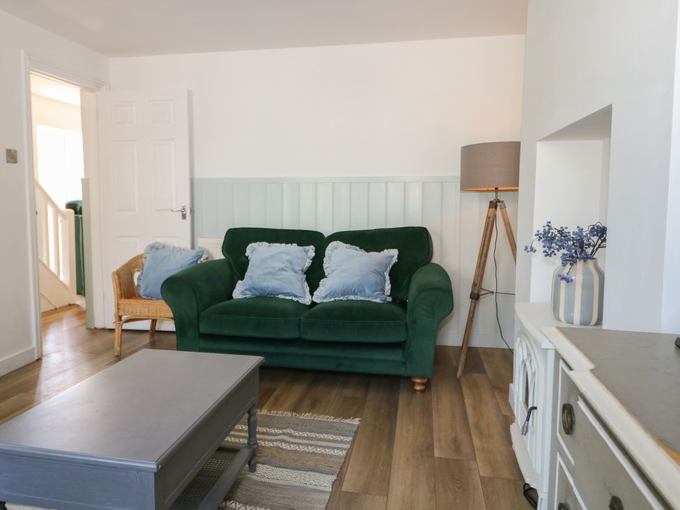 A living room with a green sofa and a lamp at East Cliff Gardens in Folkestone