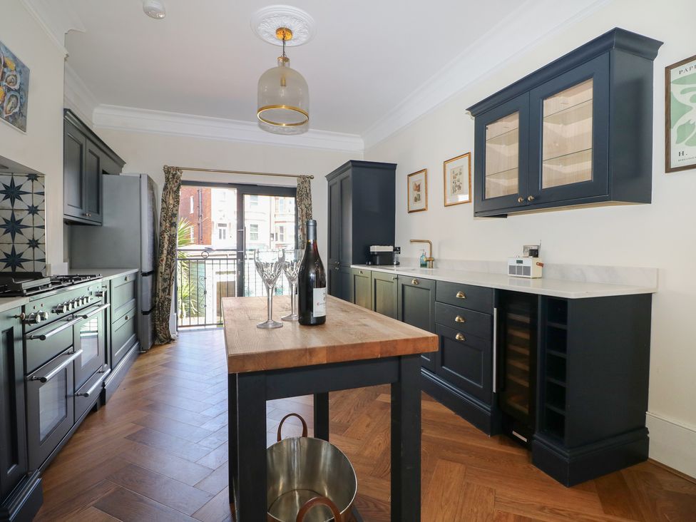 A kitchen with an island and wine rack at East Cliff Gardens in Folkestone