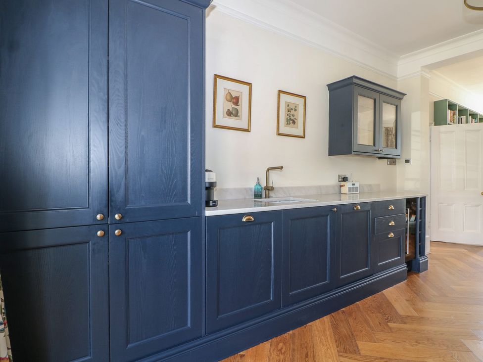 A kitchen with dark blue cabinets and a sink at East Cliff Gardens in Folkestone
