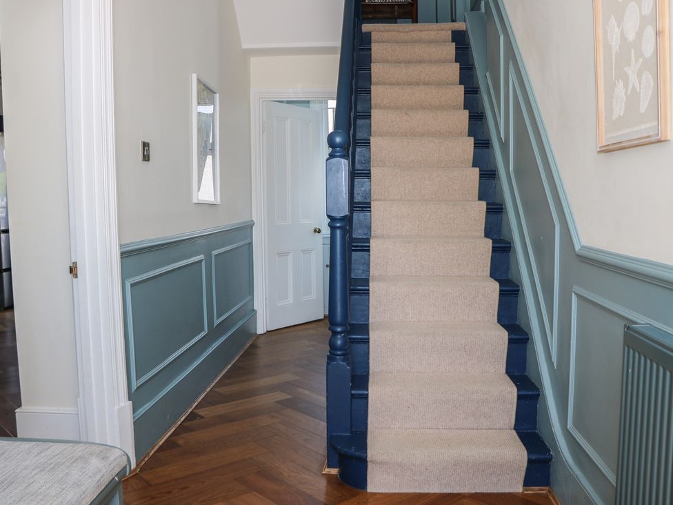 A hallway with stairs and door at East Cliff Gardens in Folkestone