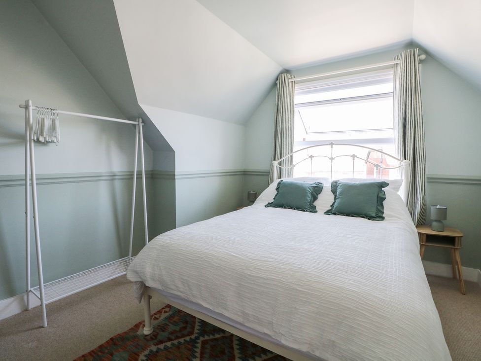 A bedroom with a bed and a clothes rack at East Cliff Gardens in Folkestone