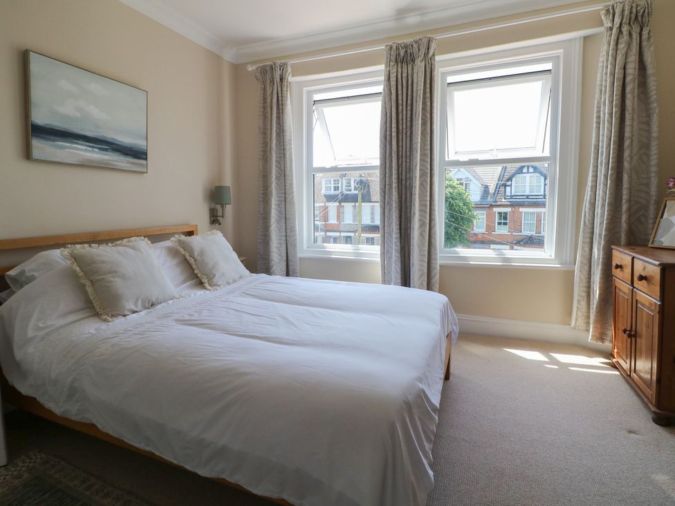 A bedroom with a bed and windows at East Cliff Gardens in Folkestone