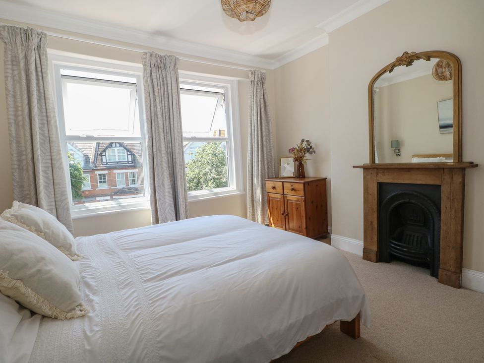 A bedroom with a bed and windows at East Cliff Gardens in Folkestone