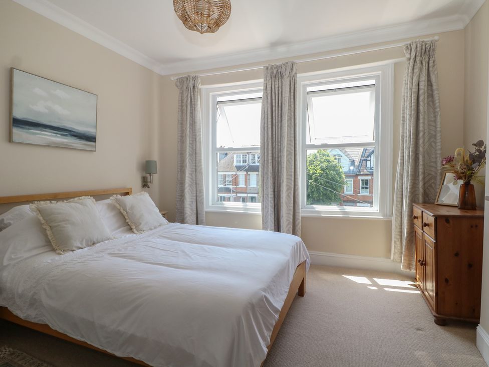 A bedroom with a bed and windows at East Cliff Gardens in Folkestone