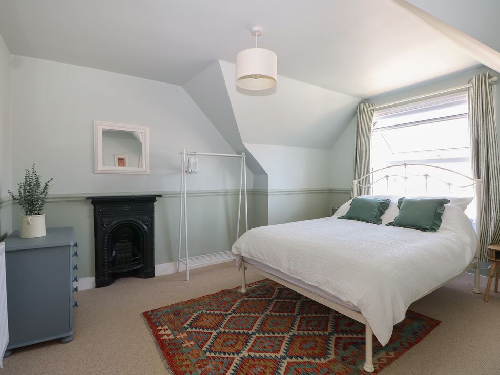 A bedroom with a bed and a fireplace at East Cliff Gardens in Folkestone
