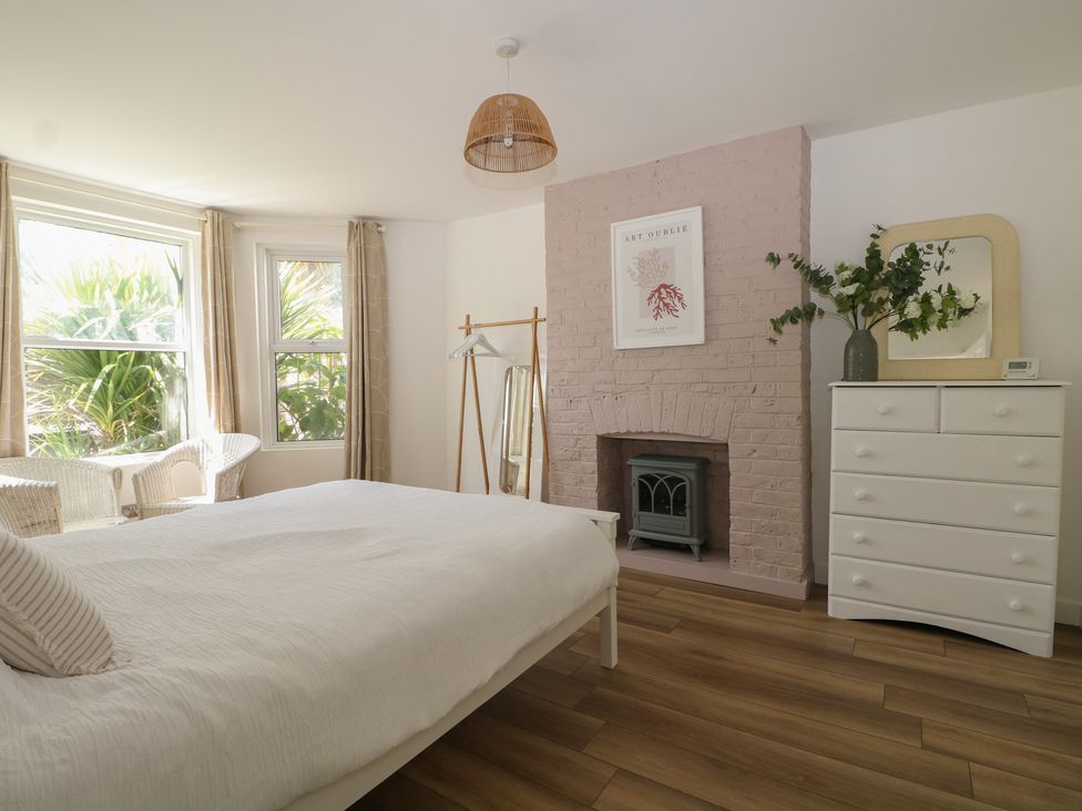 A bedroom with a bed and windows at East Cliff Gardens in Folkestone