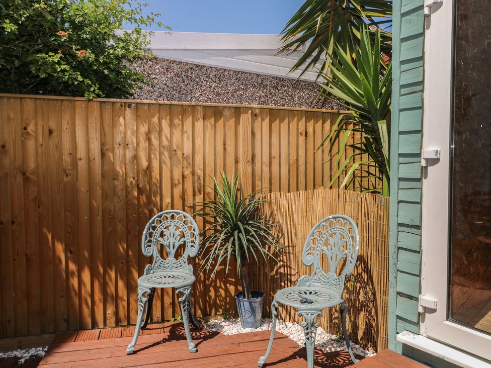 A garden with two chairs and a potted plant at East Cliff Gardens in Folkestone