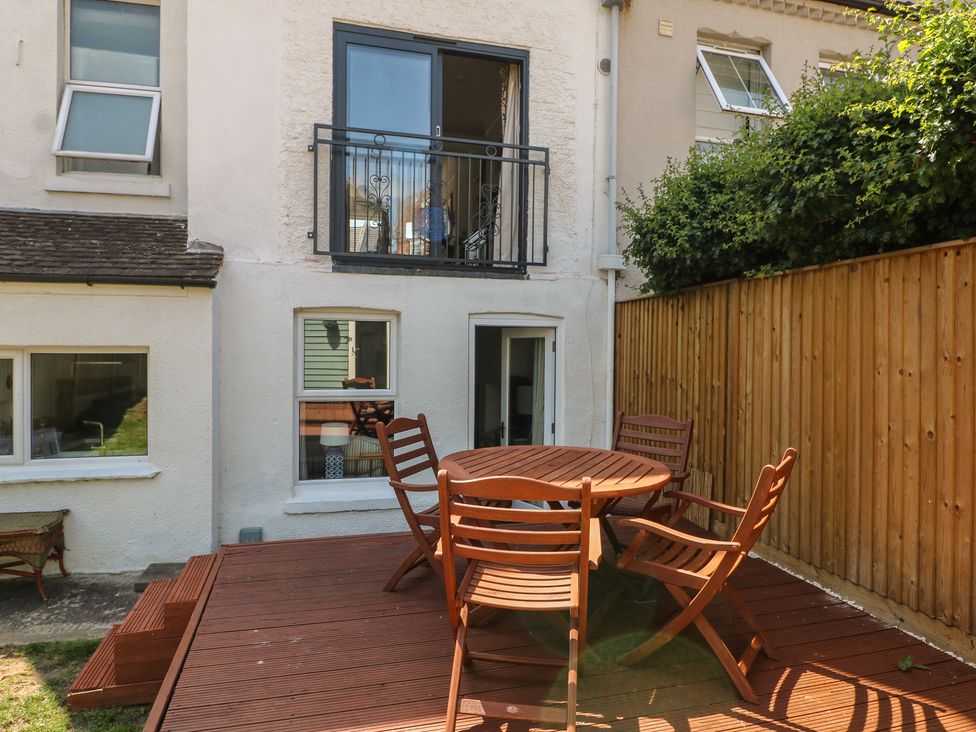 An outdoor seating area with a table and chairs at East Cliff Gardens in Folkestone