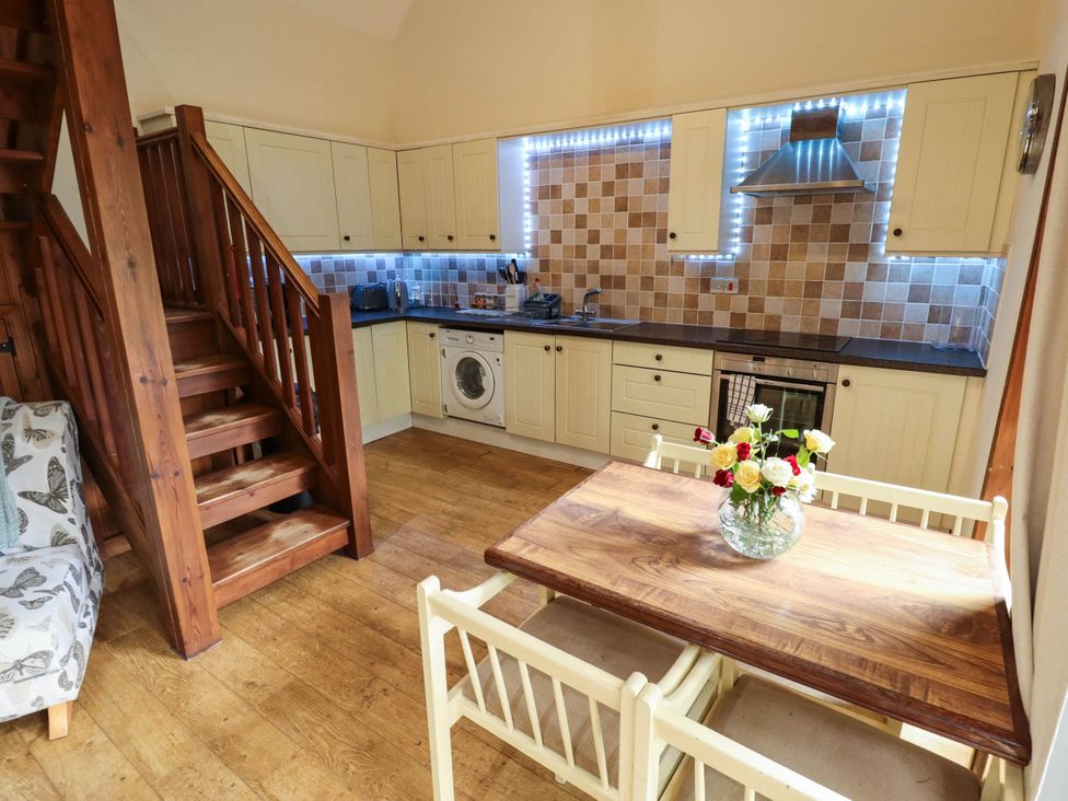 A kitchen with a table and chairs at Willow Tree Barn Spalding