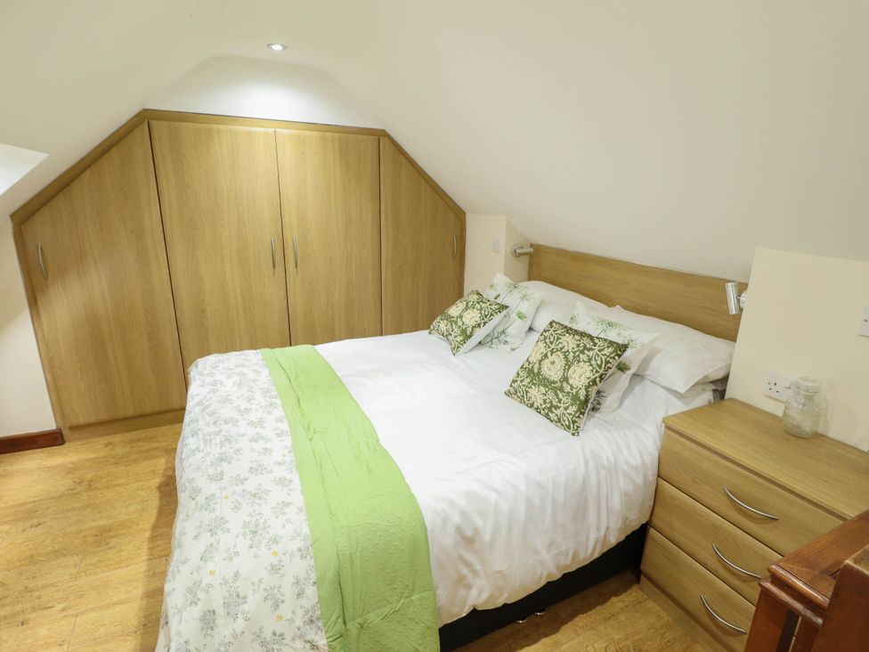 A bedroom with a bed and wardrobe at Willow Tree Barn in Spalding