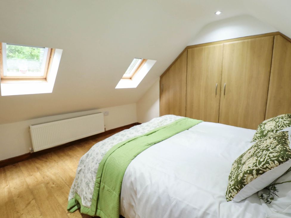 A bedroom with a bed and wardrobe at Willow Tree Barn in Spalding