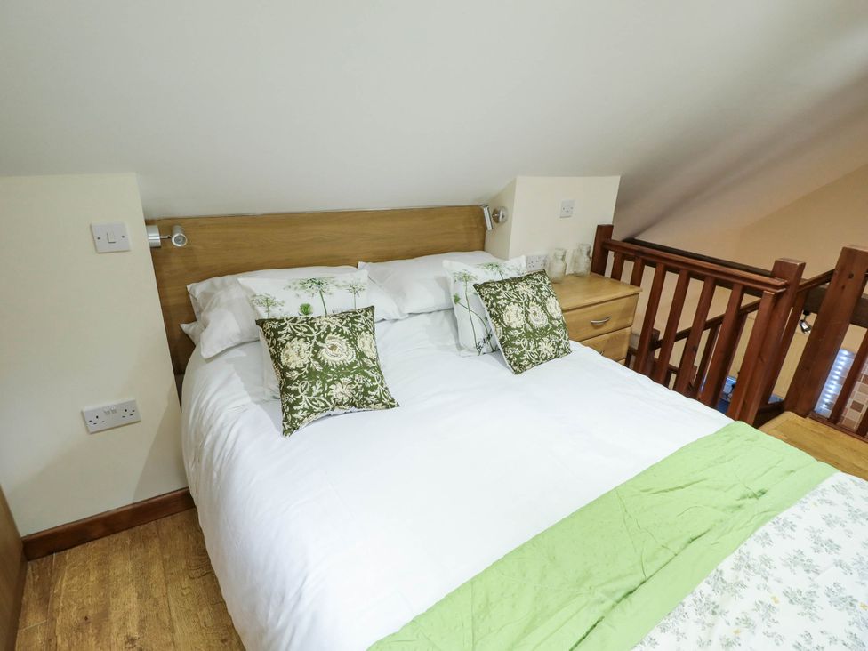 A bedroom with a bed and bedside table at Willow Tree Barn in Spalding