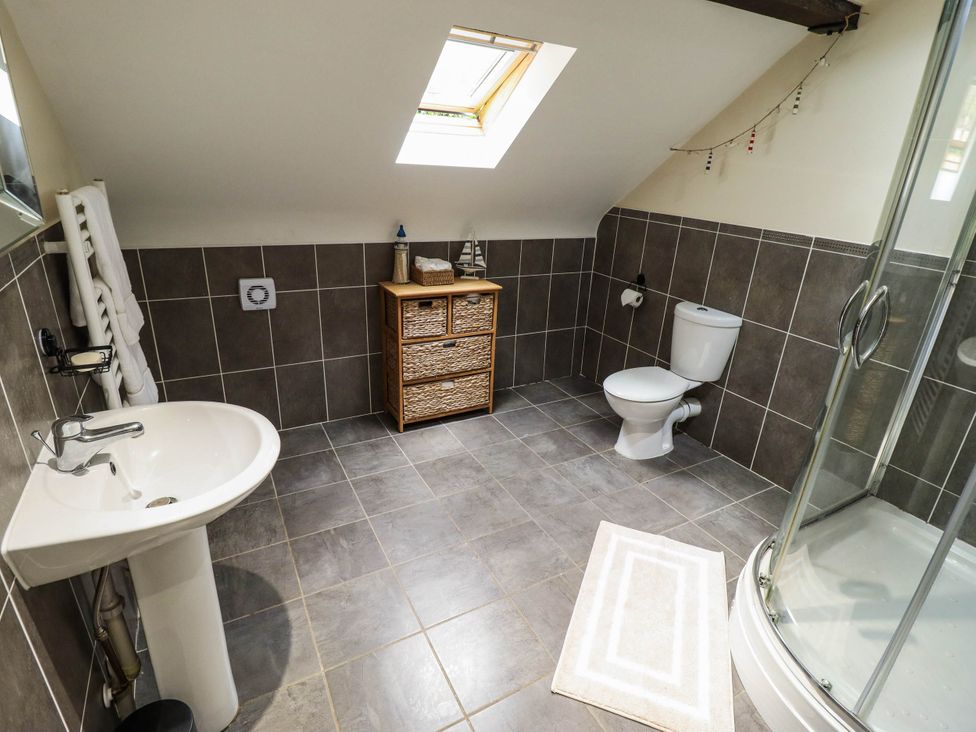 A bathroom featuring a shower, sink, and toilet at Willow Tree Barn Spalding