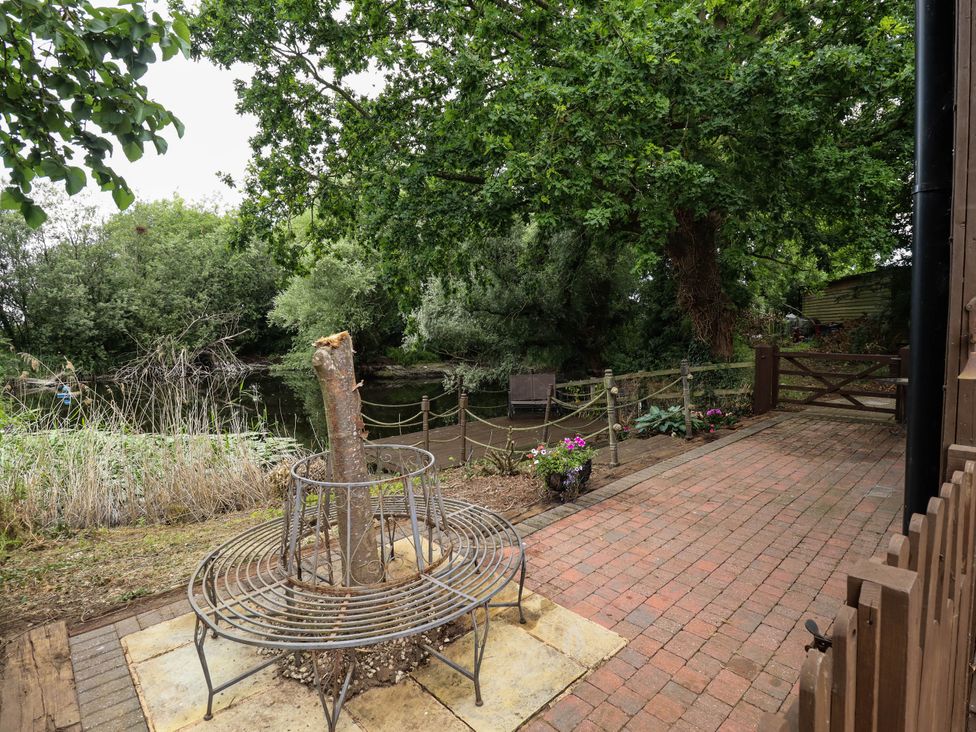 A garden with a fire pit and a view of the water at Willow Tree Barn in Spalding