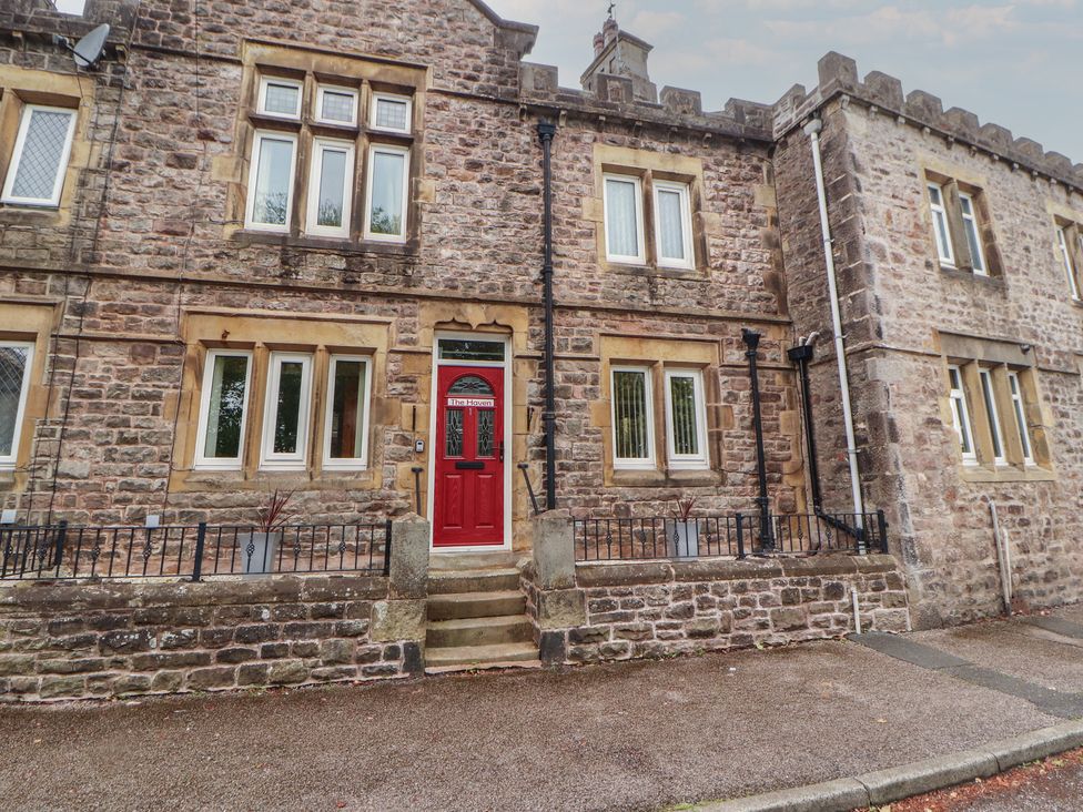 A building facade with a red door and windows at The Haven in Heysham