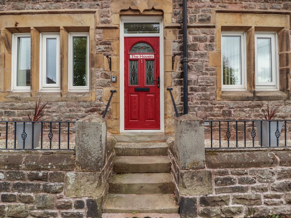 An entrance with a red door and windows at The Haven in Heysham