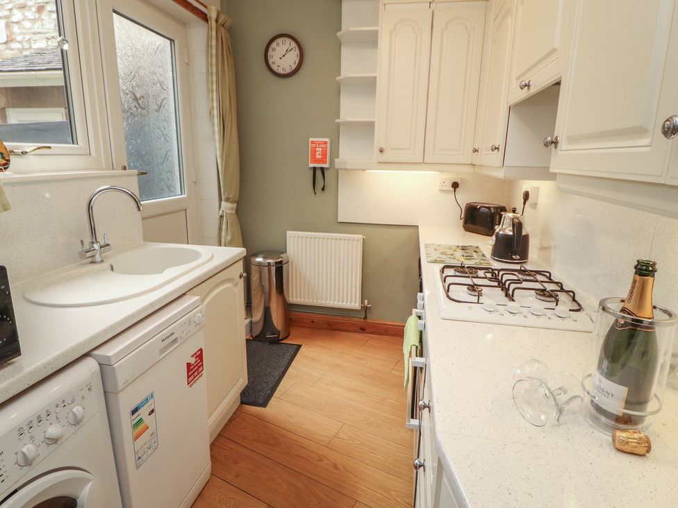 A kitchen with a sink and washing machine at The Haven in Heysham
