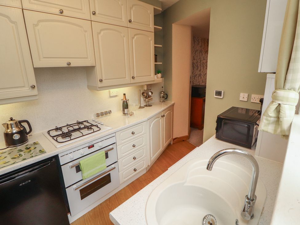 A kitchen with a stove and sink at The Haven in Heysham
