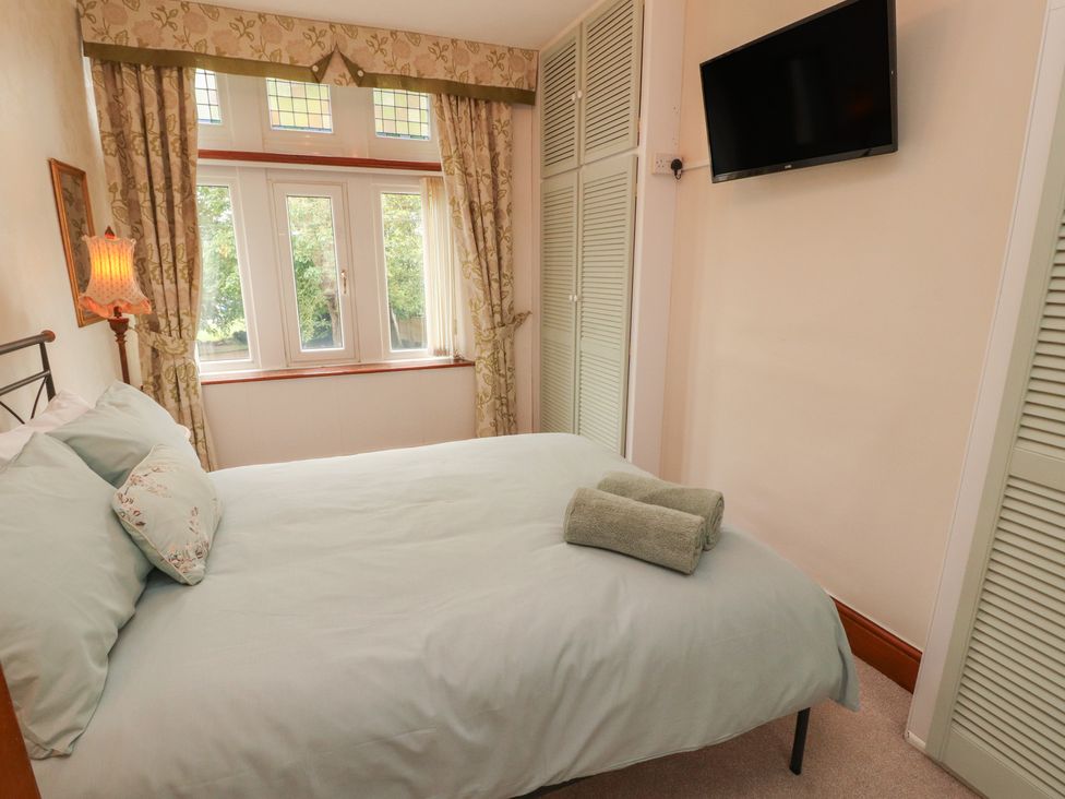 A bedroom with a bed and a lamp plus a television at The Haven in Heysham