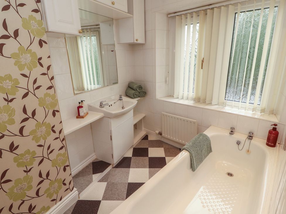 A bathroom with a bathtub and sink at The Haven in Heysham