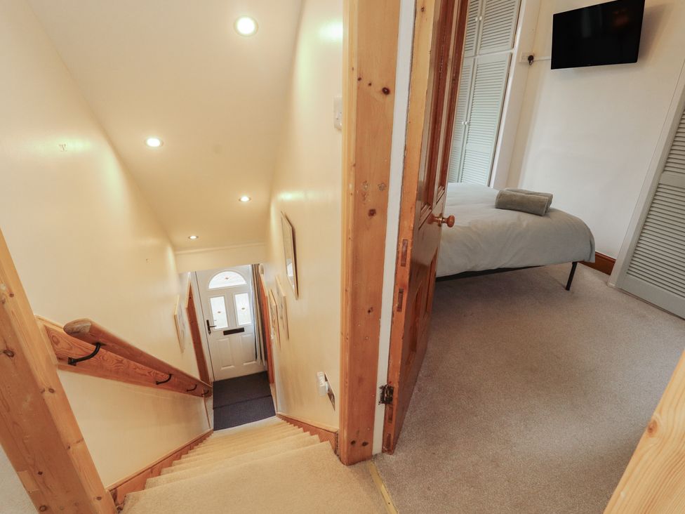 A hallway with a staircase and a door leading to a room at The Haven in Heysham