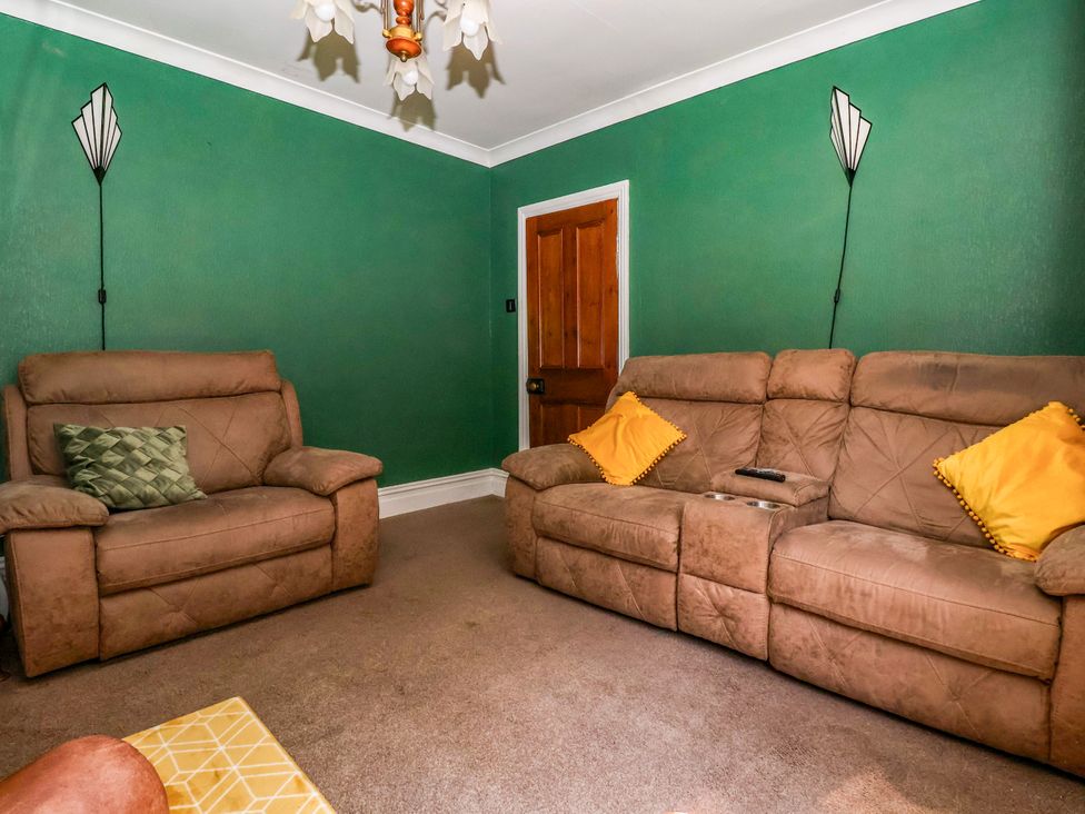 A living room with sofas and a door at the Old Post Office