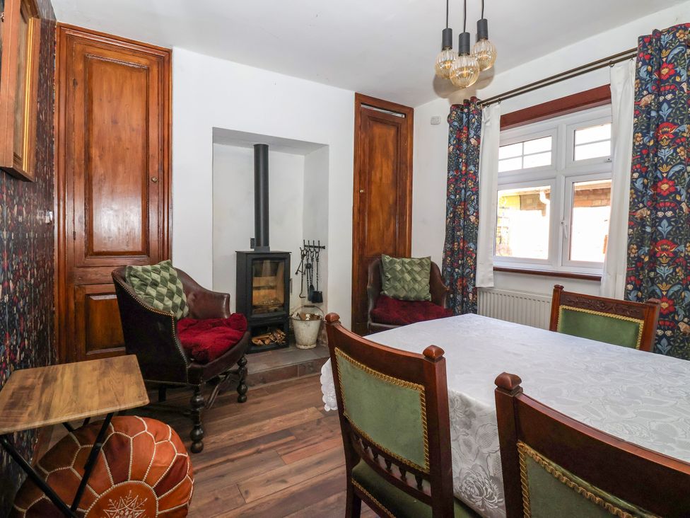 A dining room with a fireplace and wooden table at Old Post Office 
