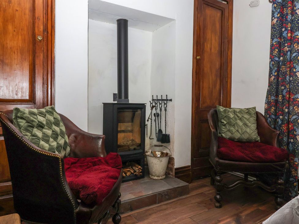 A living room with a fireplace and two armchairs at Old Post Office in 