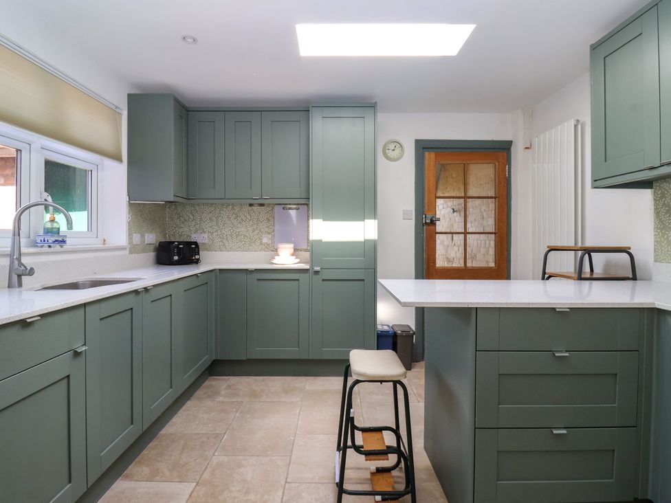 A kitchen with green cabinets and a countertop at The Old Post Office