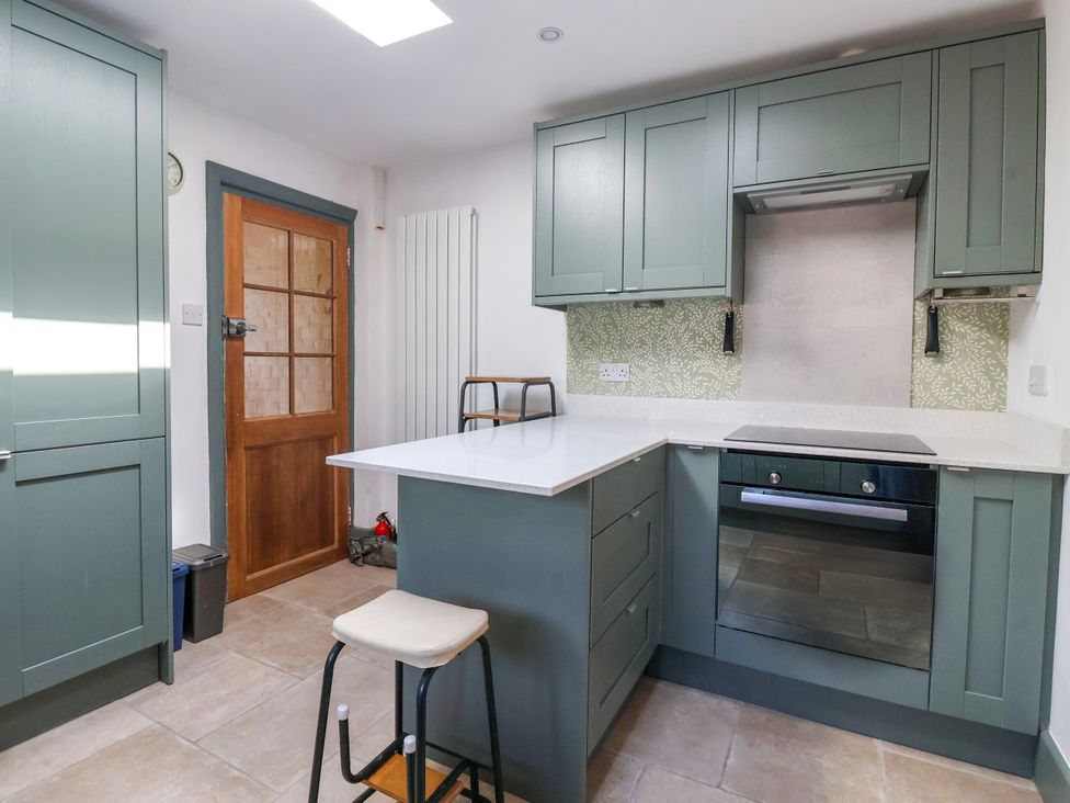 A kitchen with cabinets and stove at The Old Post Office