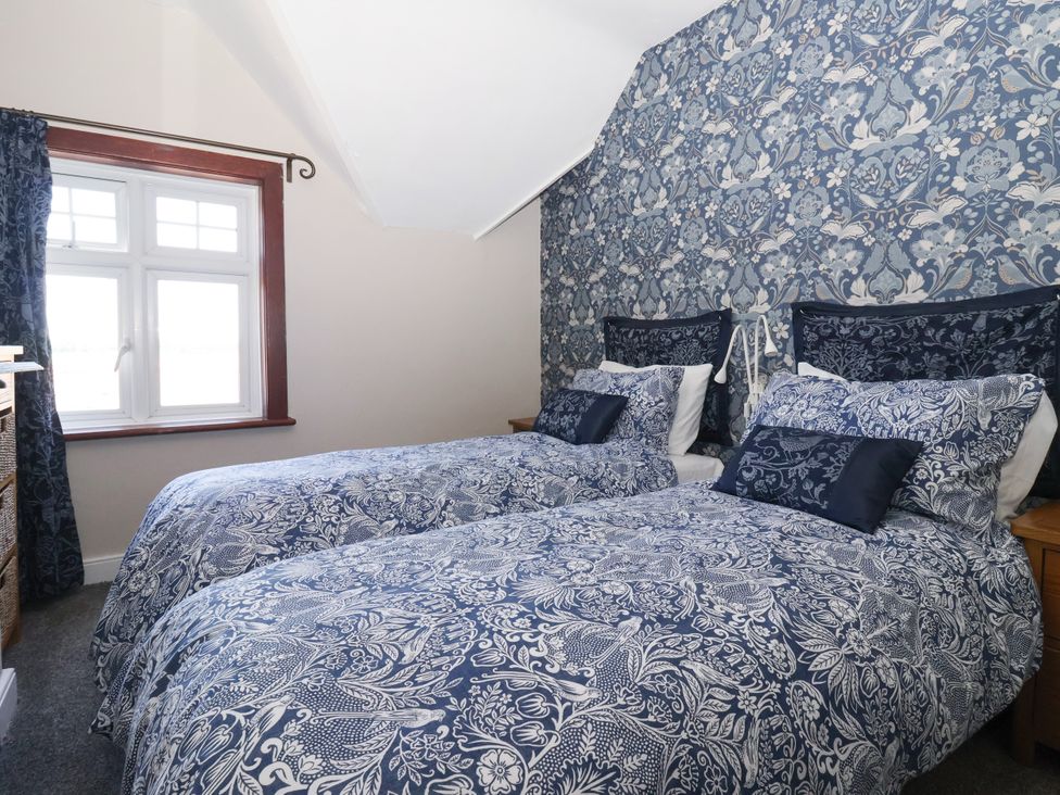 A bedroom with twin beds and a window at the Old Post Office 